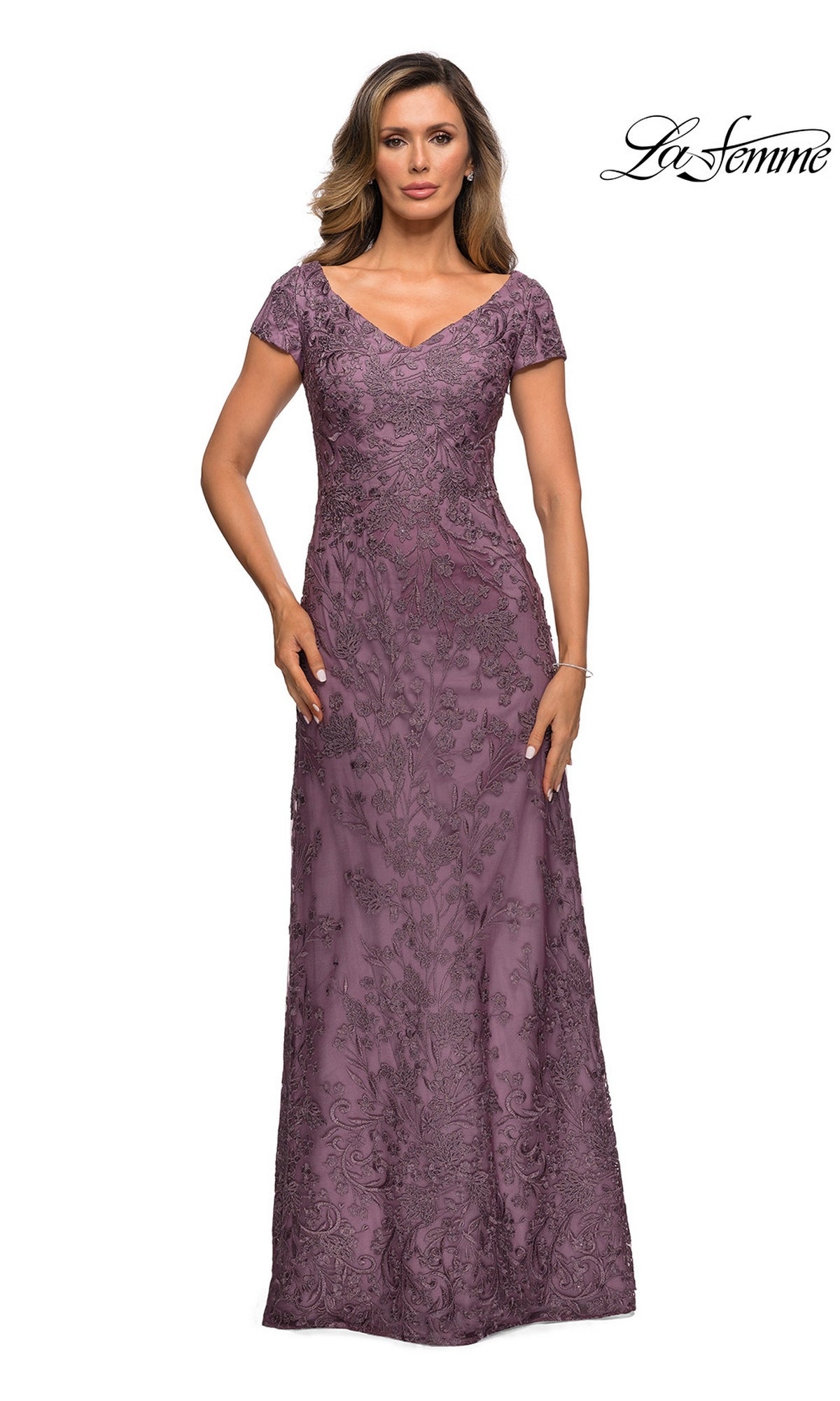 Woman in a floor-length, short-sleeve Long Formal Dress: La Femme 27915 in Dusty Lilac with floral lace embroidery, posing against a white background. “La Femme” logo top right.